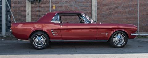 photo of a red ford mustang on a brick wall background