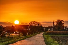 Beautiful and colorful sunset above the houses among the plants