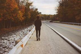 human walking on asphalt road at autumn