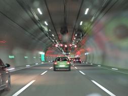 Cars in motion, on the road, in the beautiful tunnel with lights