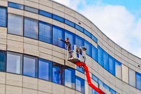 a worker washes the glass facade of a building in Dusseldorf