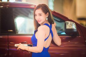 beautiful girl in a blue dress near a luxury car