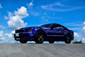 blue mustang car on the road
