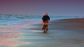 Cyclist on Beach at Morning