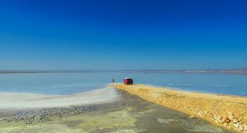 man and a car on a cape on a lake in turkey