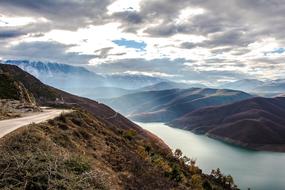 Beautiful and colorful landscape with the road, on the mountains, in sunlight, under the clouds