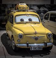 Beautiful, shiny, yellow Seat 600 car in Spain, of Walt Disney