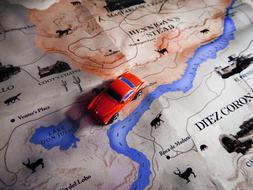 red toy car on travel map