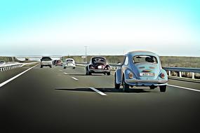 Colorful, shiny "Volkswagen" and other cars on the road, in sunlight