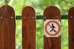 Prohibition sign on a wooden fence on a blurred background