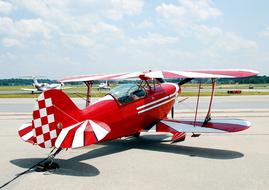 Shiny, red and white, patterned airplane in the airport