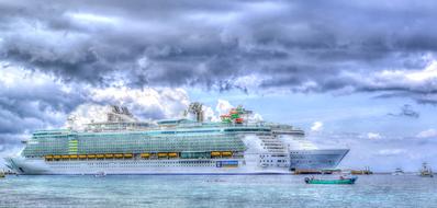 Colorful and beautiful cruise ship and boat on the water, above the cloudy sky