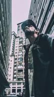 stylish young man among skyscrapers on city street