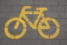 Yellow bike sign on the lane with pavement