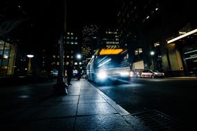 Bus and cars in movement on the road of the city with colorful lights at beautiful night