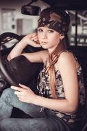 Portrait of a blonde girl in military style, in the car