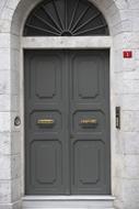 Old, beautiful retro door with the arch, on the stone building