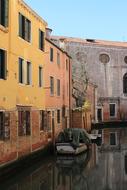 Beautiful landscape of the channel, with the boat, near the colorful buildings, in Venice, Italy
