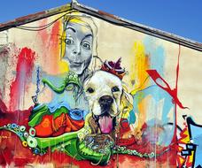 Colorful and beautiful graffiti with the dog and face, on the wall in Cyprus, Greece, at blue sky on background