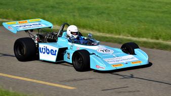 Person in the colorful racing car, on the road on the hillclimb, on the Cosworth Formula 2