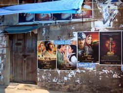 photo of a movie poster on the wall of a building in India