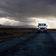 Automobile on Asphalt road and cloudy sky