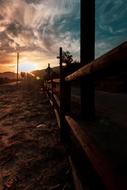 fence along the field against the background of sunset