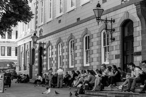 tourists on the steps of a building in black and white background