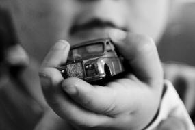 Black and white photo of the cute child with the car model