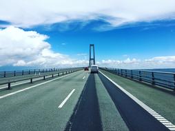 Cars on the beautiful Denmark-Sweden bridge, under the blue sky with white clouds