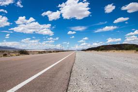 Beautiful landscape of the highway in California, USA, among the colorful mountains, under the blue sky with white clouds