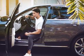 photo of a cute asian guy driving a car