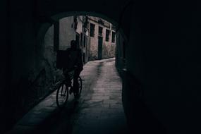 cyclist rides a dark street