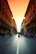 people on a city street at sunset