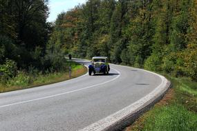 Veteran Car on road in forest