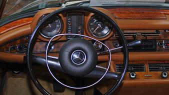 Black steering wheel of the Mercedes car, with the beautiful, brown and black interior