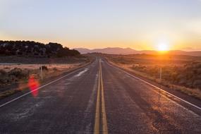 sunrise over an empty asphalt highway