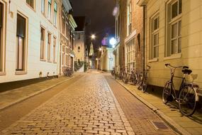 bicycles along the houses on the street of the old city at night