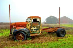 Colorful, rusty, vintage truck, among the beautiful and colorful field, near the barn, on the farm