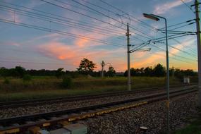 Beautiful landscape of the rails, among the beautiful and colorful fields, with the plants, at beautiful and colorful dusk