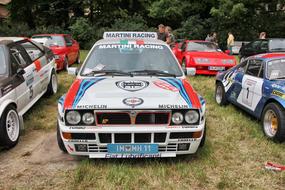 racing cars in a parking lot on the grass