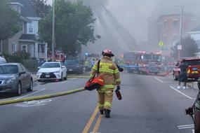 Back view of the firefighter near the fire in Boston, USA