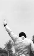 guy with his hand raised up, view from the back