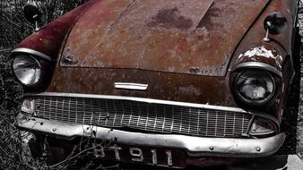 Black and white photo of the old, beautiful, retro, rusty car with headlights