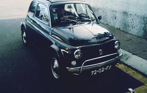Beautiful, shiny, vintage black car in light, on the street