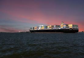 cargo ship at sea at sunset