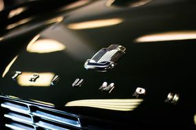 Beautiful, shiny, black car with the logo and Triumph sign, in light