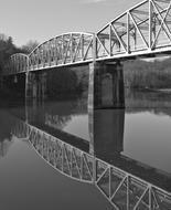 monochrome photo of steel railway bridge over the river