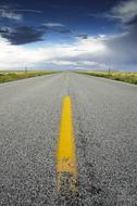 Beautiful landscape with the road with yellow lines, among the colorful fields