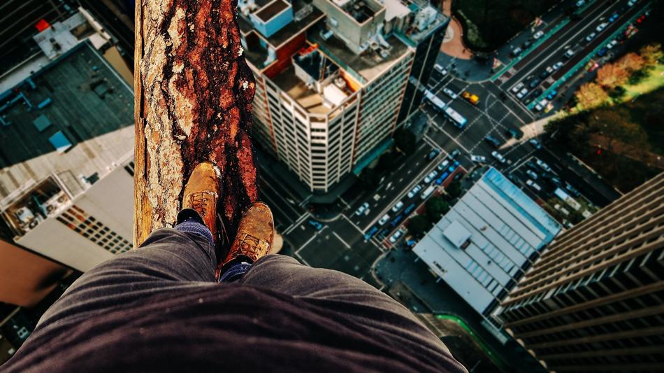 Person, balancing on the wood, above the colorful city in light
